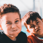 Two elementary school boys with silly faces showing positive learning environment