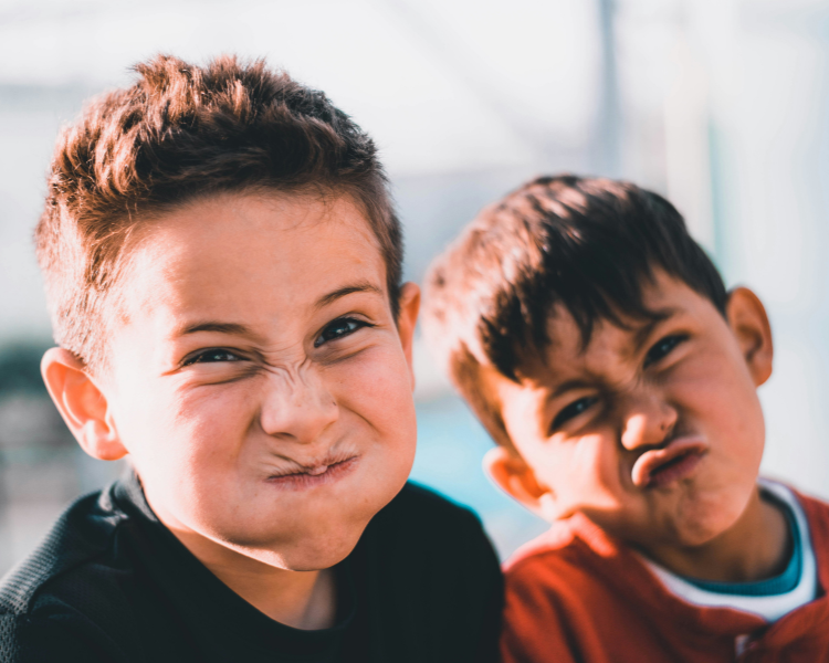 Two elementary school boys with silly faces showing positive learning environment