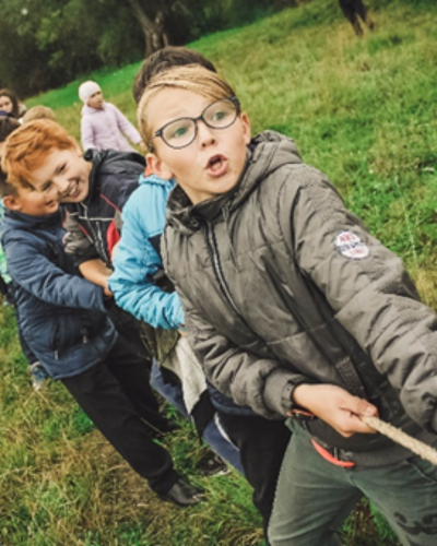 Children pulling a rope together, showing teamwork in collecting a set of resources for those who learn differently