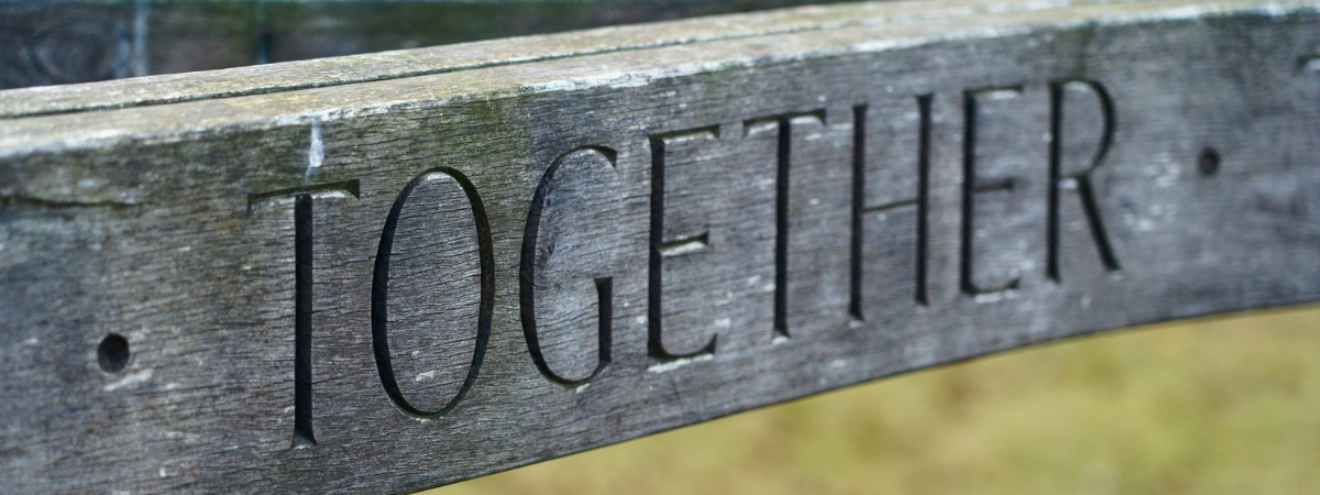 The word 'together' carved into a piece of wood showing the importance of teaching and learning together