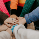 People putting hands together to show teamwork.