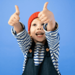 Child in overalls and red cap with thumbs up, showing approval for signing up for newsletter